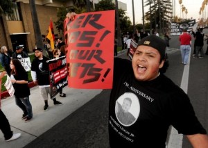 ROB VARELA/THE STAR Leonardo Suarez leads a chant outside the Oxnard Police Department as marchers marking the year anniversary of Alfonso Limon Jr.’s shooting by Oxnard police, make their way through the streets of Oxnard on Sunday.